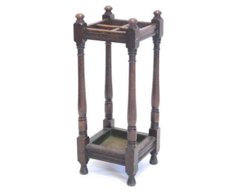 An early 20thC oak stick stand, with four sectional compartments, with a lead lined base on turned feet, 73cm high.