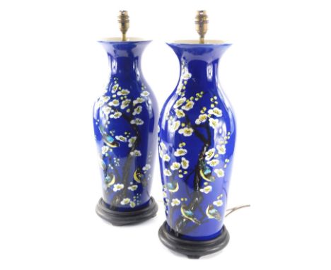 A pair of Japanese pottery lamp vases, each of shouldered form with compressed trumpet stems, profusely decorated with birds,