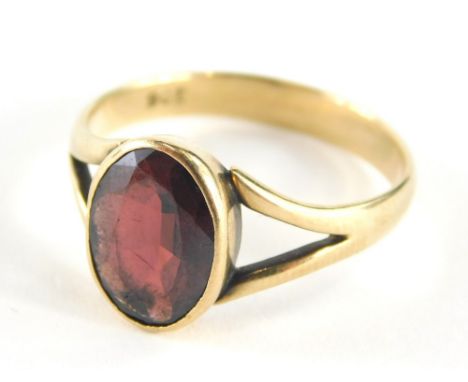 A 9ct gold garnet dress ring, with oval garnet in rub over setting, on v splayed shoulders, marked 9ct, ring size Q½, 3g all 