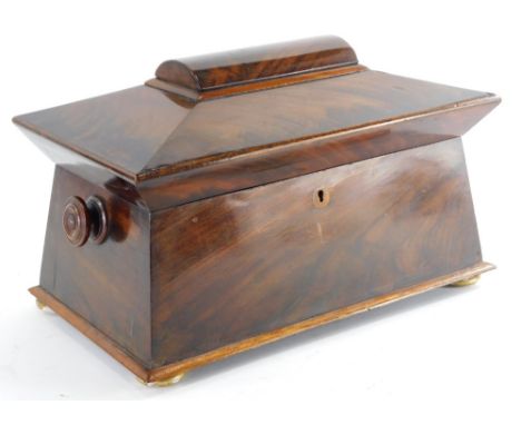An early Victorian figured mahogany sarcophagus shaped tea caddy, the hinged lid enclosing a fitted interior, on bun feet, 35