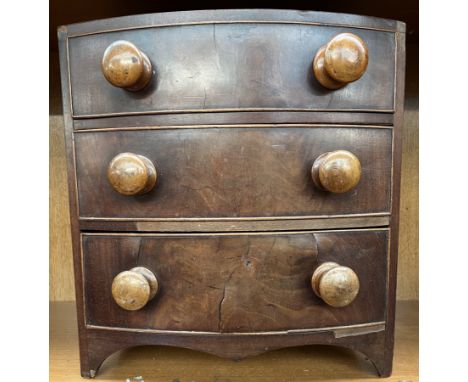 A miniature Victorian mahogany chest with a bowed top above three long drawers on bracket feet, 33.5cm wide 