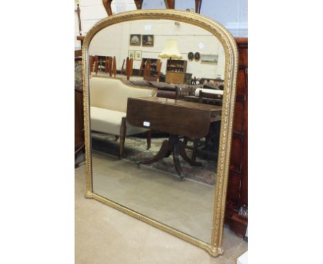 A Victorian gilt gesso over-mantel mirror with arched top, 133cm high, 114cm wide.