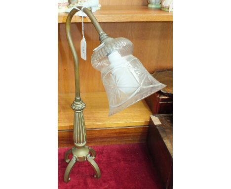 A brass desk lamp with reed column on four shaped feet, with clear glass shade, 47cm high.