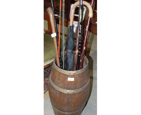 An oak coopered barrel stick stand, 53cm high, with contents including a carved turtle head walking stick, (a/f), shooting st