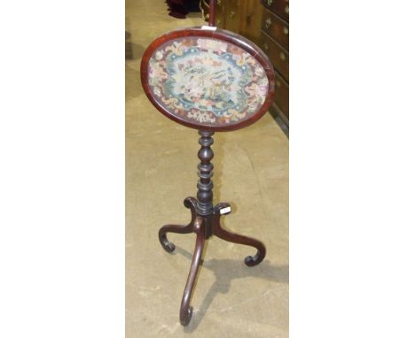 An early-19th century pole screen, with wool-work panel set within oval frame, on turned column and tripod base, 139cm high.