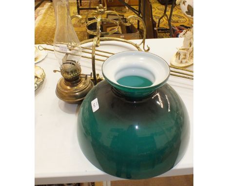 A brassed hanging fitting with oil lamp, green glass shade and three hanging rods.