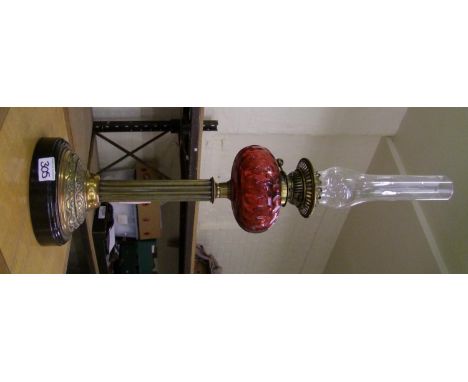 A brass and cranberry oil lamp: with chimney but no shade. Height 75cm 