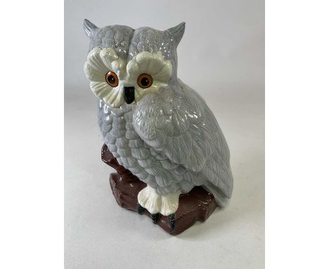 A large ceramic eagle owl seated on a tree stump, no signature to base, height 42cm.