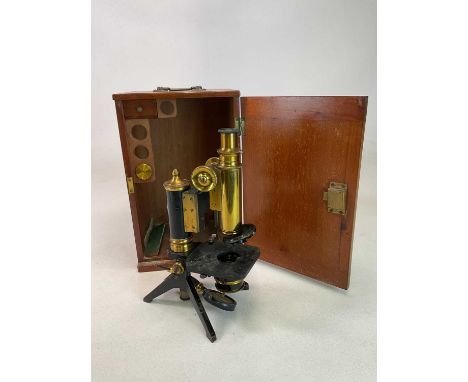 An early 20th century mahogany cased unnamed brass and lacquered monocular microscope, height approx 32cm, with one unnamed a