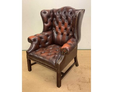 A late 20th century brown leather button back wingback chair, with studded detailing to the framework, height of back 110cm, 