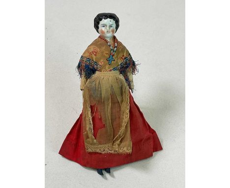 A 19th century European painted ceramic head doll with bisque limbs and a cloth body, in original clothes, height 25cm.