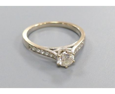 A diamond solitaire ring with diamond-set shoulders, 18ct white gold setting, size L, gross 3.2 grams.