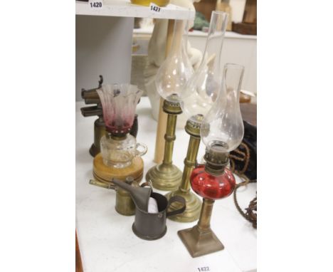 A pair of candle storm lamps, two oil lamps, a paint stripper, a jeweller's blow lamp and oil can, tallest 49cm