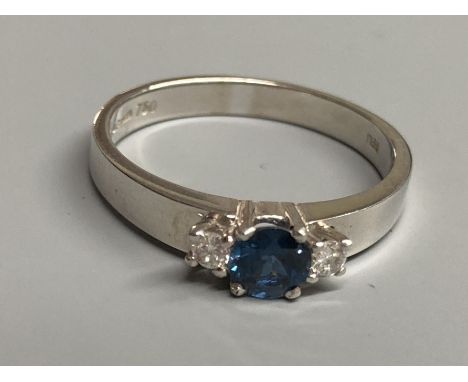 A modern 18ct white gold, sapphire and diamond set three stone ring, size N/O, gross 3.2 grams.