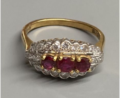 A modern 18ct gold, ruby and diamond set ovoid cluster ring, size M, gross 4.4 grams.