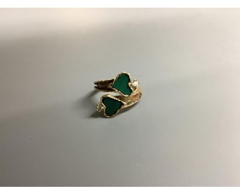 A modern yellow metal, two stone heart shaped malachite and two stone diamond set crossover ring, size F/G, gross 3.9 grams.