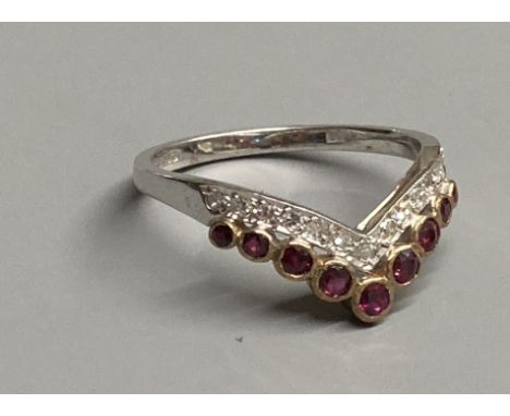 A modern 18ct gold, two row ruby and diamond set chevron ring, size M/N, gross 2.1 grams.