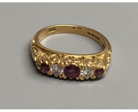 A modern Victorian style 18ct gold, three stone ruby and two diamond set half hoop ring, size N, gross 6.2 grams.