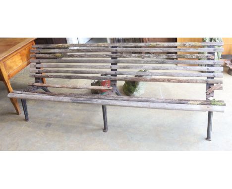 A slatted wood garden bench marked L M Furniture (in need of repair), length 244cm, depth 70cm, height 77cm