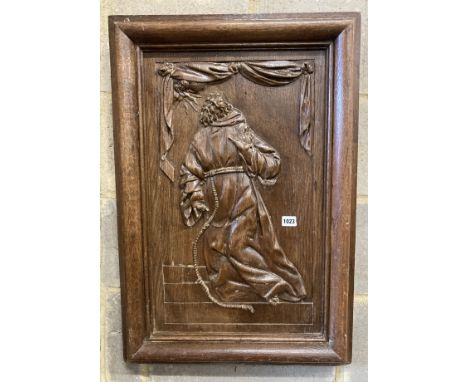 A rectangular carved oak wall panel depicting religious scene