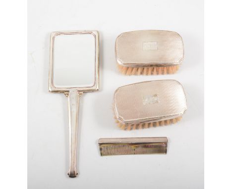 Silver back dressing table mirror, Birmingham 1990, engine turned, 26cm; silver mounted comb and two clothes brushes.