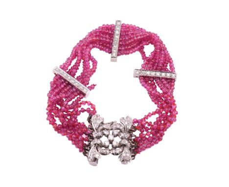 A ruby bead bracelet with a diamond-set clasp, comprising eight rows of spherical ruby beads of 2.0 mm, hand-knotted to three