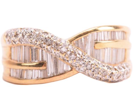 A diamond crossover ring, set with baguette-cut diamonds and rows of round brilliant cut diamonds, some synthetic, leading to