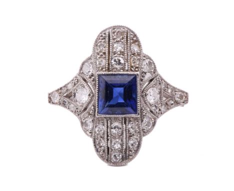 An Art Deco sapphire and diamond ring, circa 1920s, set to the centre with a rectangular step cut sapphire, within a scallope