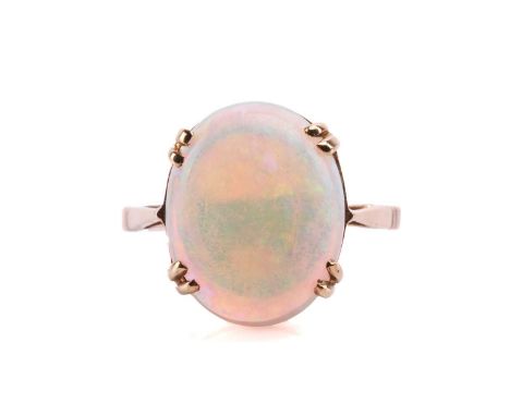 An opal solitaire ring, featuring an oval cabochon of a translucent precious opal displaying spectral play-of-colour on a lig