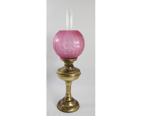 A brass oil lamp, with etched ruby glass shade, Sun clear glass funnel, 62cm 