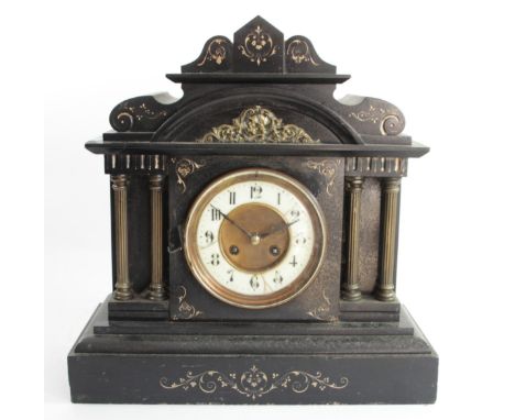 A late 19th century French black slate mantel clock, the ivorine dial to a signed movement, striking on a gong, the architect