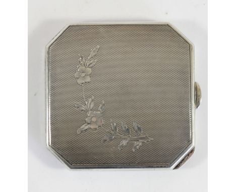 A silver compact, Birmingham 1953, with engine turned and floral decoration, mirror and powder holder. 