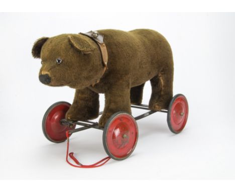 An unusual Chad Valley bear on wheels 1930s,  With dark brown mohair, clear and black glass eyes with remains of brown painte