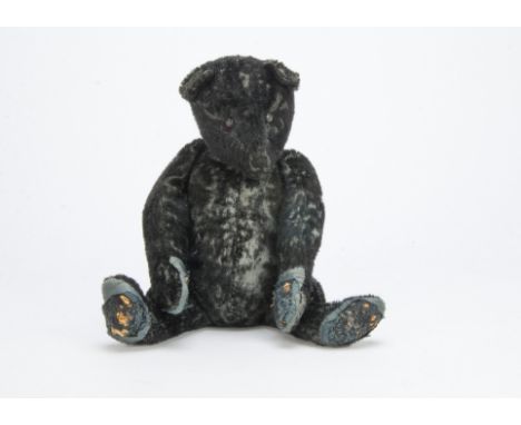 An unusual black mohair teddy bear 1920s,  Probably German with shorter plush, black boot button eyes, pronounced muzzle, res