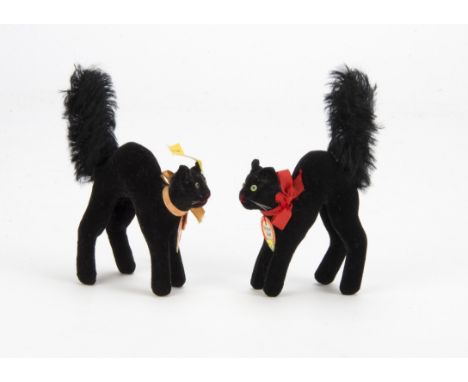 Two Steiff post-war black cats, with black velvet, green and black glass eyes, red stitched nose and mouth, whiskers, black m