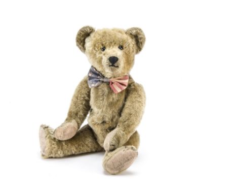 An early American teddy bear possibly Ideal circa 1908, with dark blonde mohair, black boot button eyes, pronounced muzzle, b