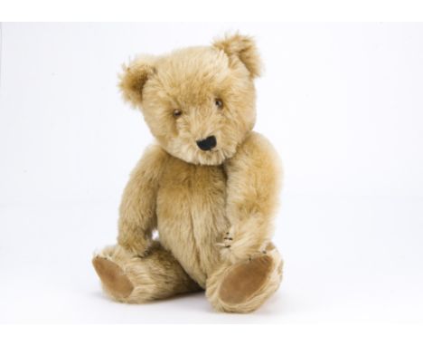 A post-war Chiltern Hugmee teddy bear, With blonde mohair, orange and black plastic eyes, black stitched nose, mouth and claw