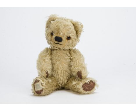 A post-war Chad Valley teddy bear, With light golden curly mohair, orange and black glass eyes, black stitched nose and mouth