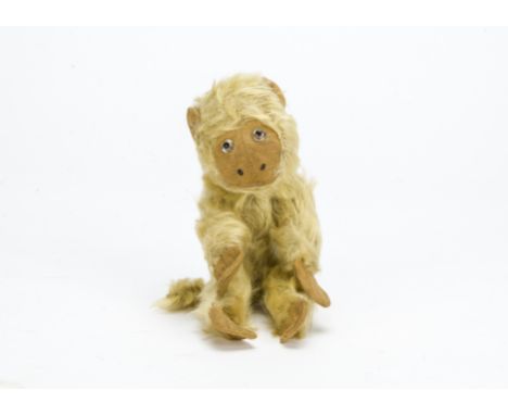 An early Chad Valley monkey, with light golden mohair, clear and black glass eyes, light brown cloth face, ears, hands and fe