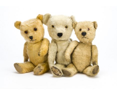 Three post-war Chiltern Hugmee teddy bears, One golden and one blonde, glass eyes and black stitched nose and mouth; and anot