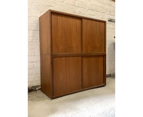 A Pair of mid century teak cupboards, formerly part of a modular wall unit, each with twin sliding doors, one with an adjusta