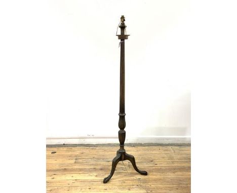 A Georgian style mahogany standard light, the leaf carved, turned and fluted column raised on triple splay supports with ball