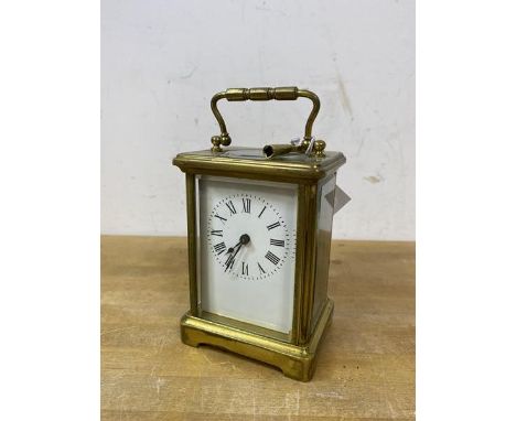 A four glass carriage clock, roman numerals to dial, measures 14cm high to top of handle