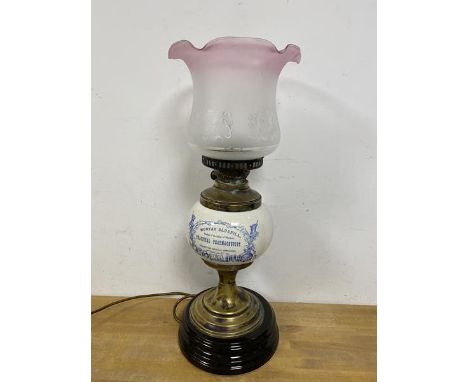 An Edwardian oil lamp converted to electric, with shade, the ceramic reservoir inscribed Mortar Bluepill Practical Pharmacist