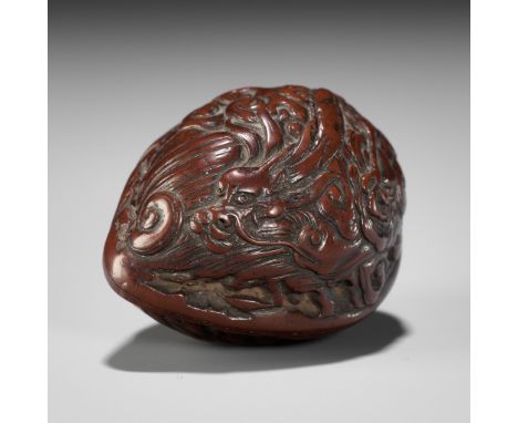 A FINE KURUMI (WALNUT) NETSUKE WITH CELESTIAL DRAGONUnsignedJapan, 19th century, Edo period (1615-1868)Of natural shape, the 