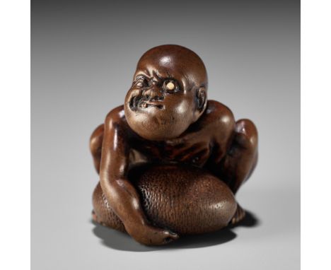 GYOKUSAI: A FINE WOOD NETSUKE OF A BLIND MASSEUR LIFTING A CHIKARAISHIBy Gyokusai, signed Gyokusai 玉哉 Japan, Edo (Tokyo), c. 