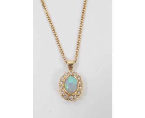 18ct gold opal and diamond pendant with an oval opal surrounded by a border of fourteen brilliant cut diamonds, on 18ct gold 