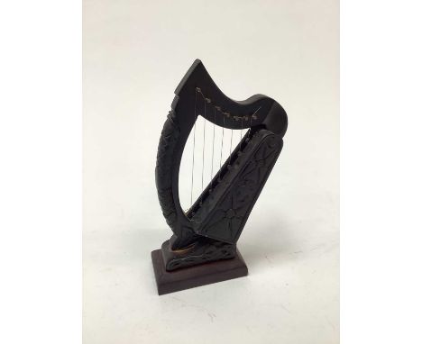 Irish Bog oak carving of a harp on wooden stand, 18.5cm high