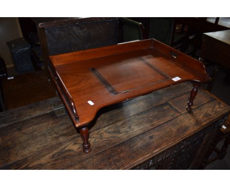 Vintage mahogany bed table^ central adjustable reading slope and gallery surround on short moulded supports^ 61cm wide