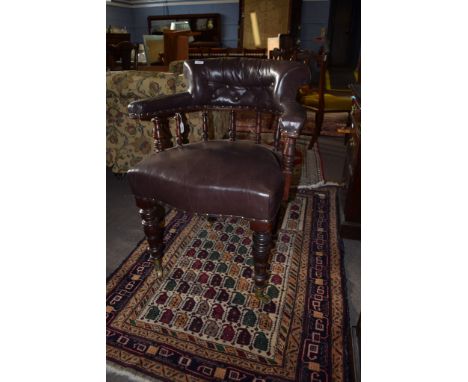 Late 19th century mahogany framed desk tub chair^ upholstered in brown leather button back raised on ring turned front suppor